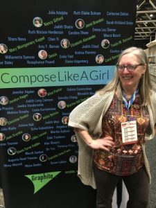 Female Composer standing by a poster that lists dozens of women composers.