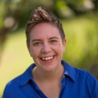 headshot of Kristen Stinnett, smiling white woman with short brown fauxhawk