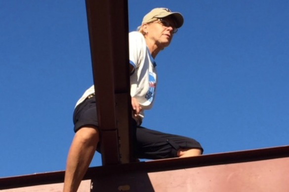 Ann Wunderlin squats on a rooftop over a girder