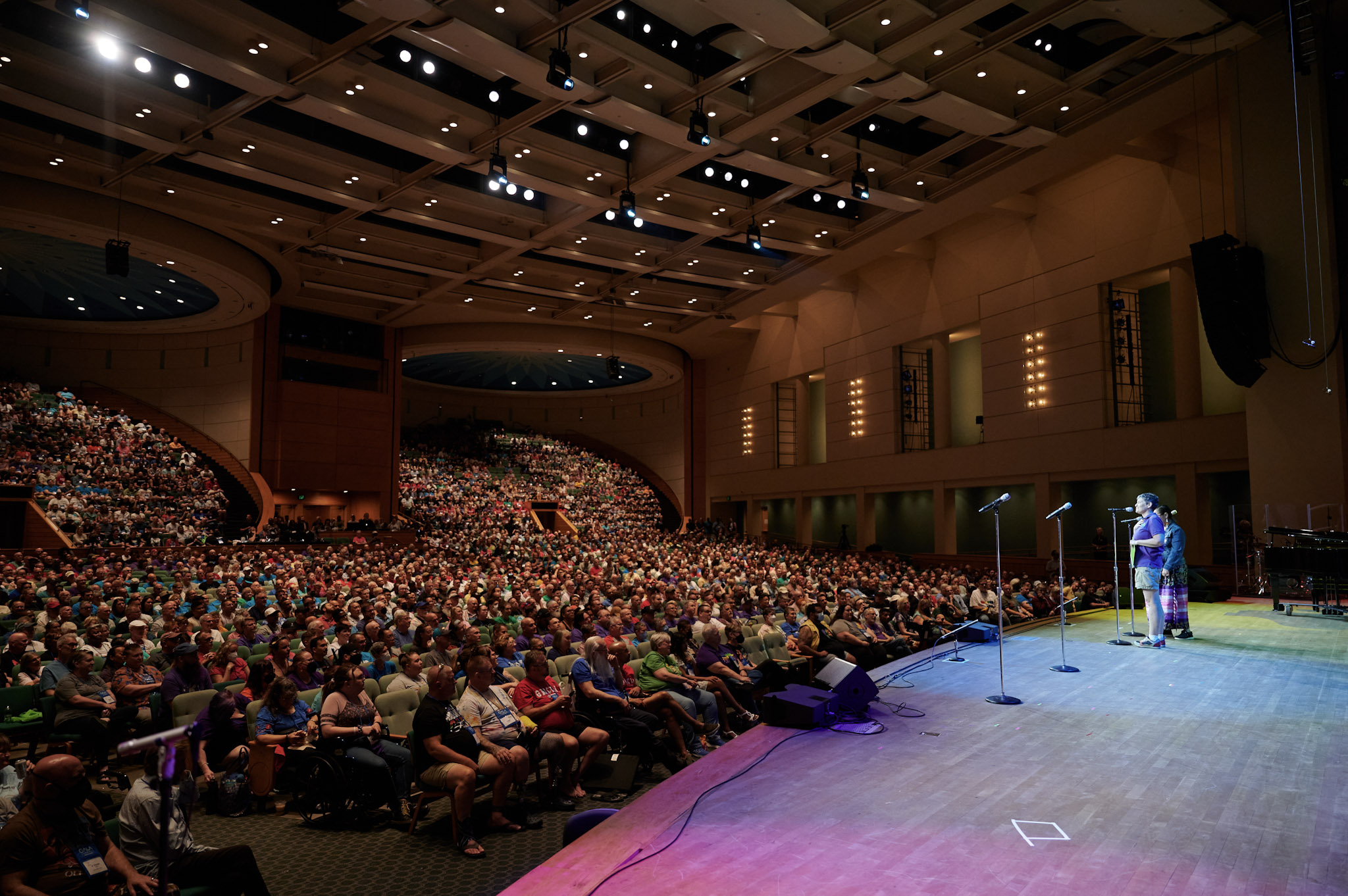 A huge crowd at the Minneapolis Convention Center Stage watches Jane Ramseyer Miller and a guest artist at Festival 2024.