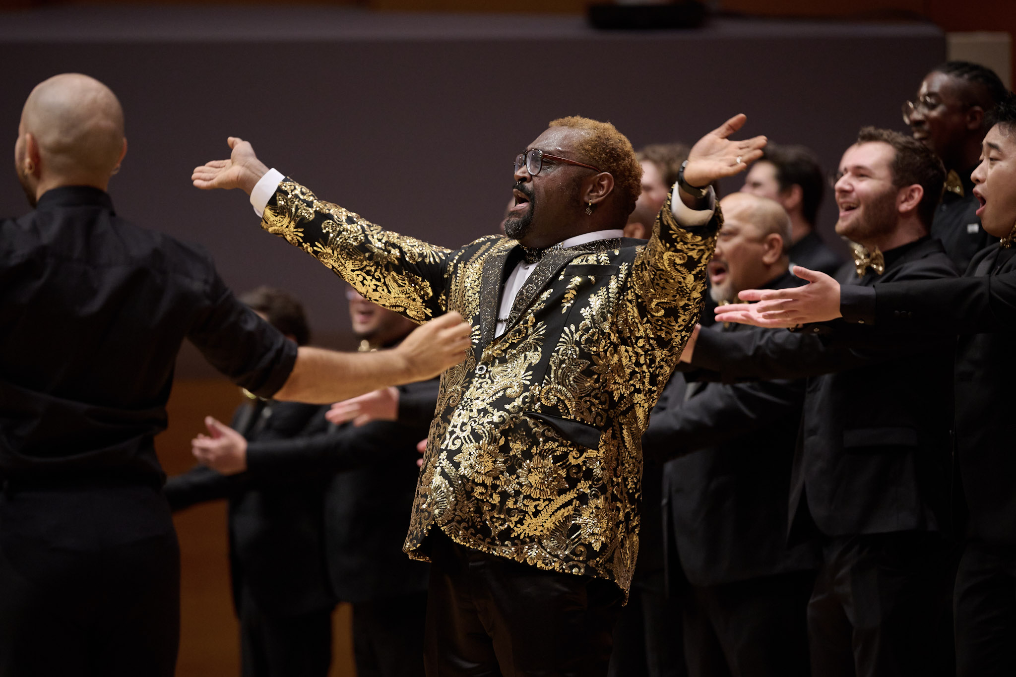 EJ Harrison, wearing a gold-embroidered blazer, performs with Gay Men's Chorus of Los Angeles at Festival 2024.