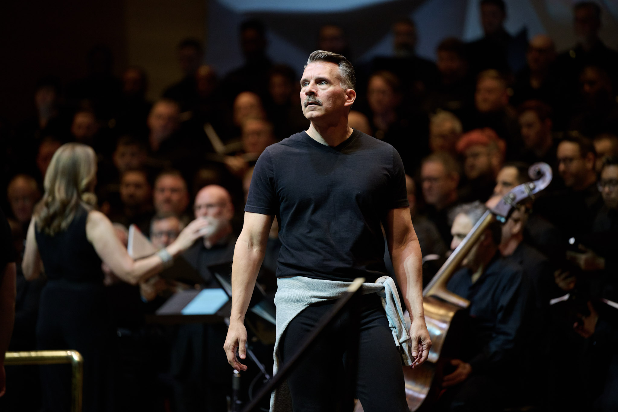 A dancer dressed in black stands in front of the Gay Men's Chorus of Washington, DC, performing at Festival of 2024.