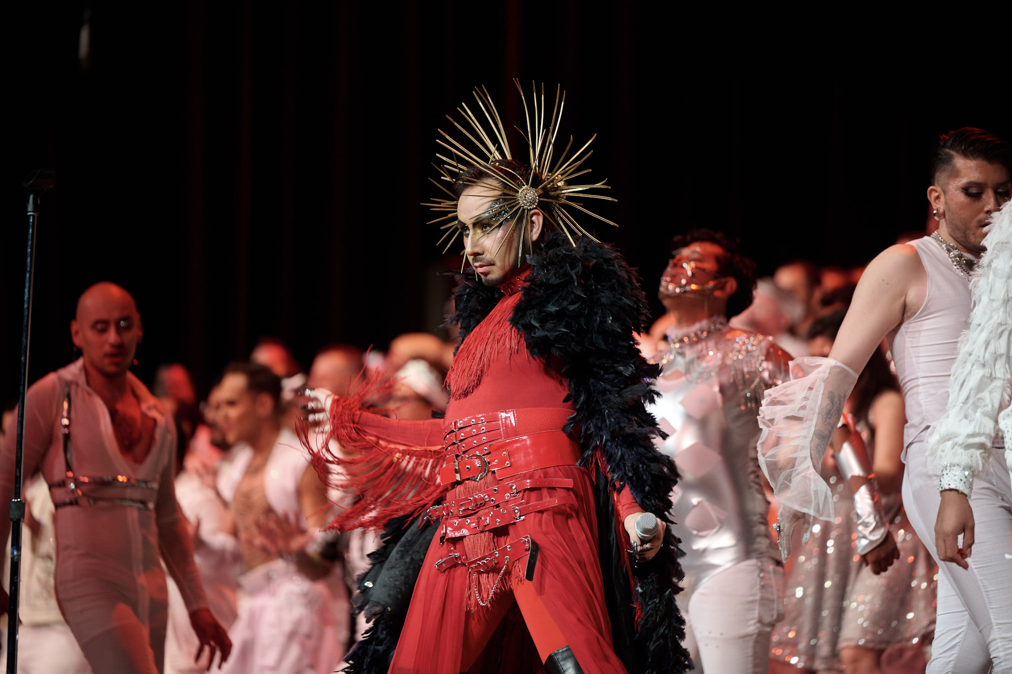 A performer, dressed in red, sings with members of Coro Gay de Ciudad de Mexico at Festival 2024 in Minneapolis.