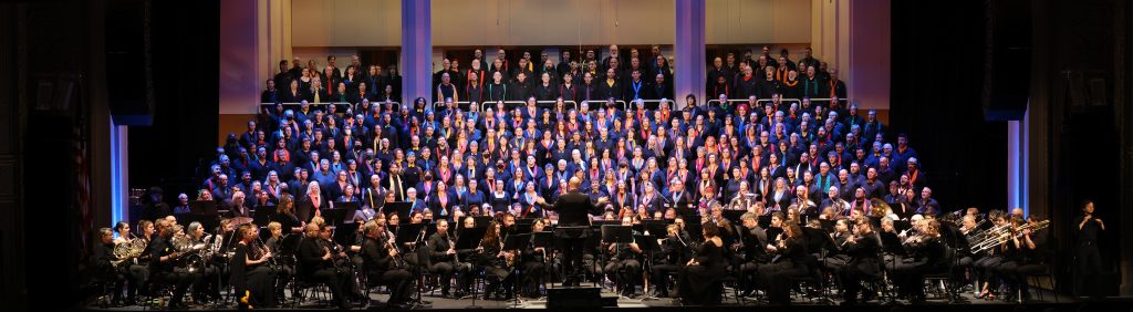 375 performances stand on stage for Our New World in Portland.