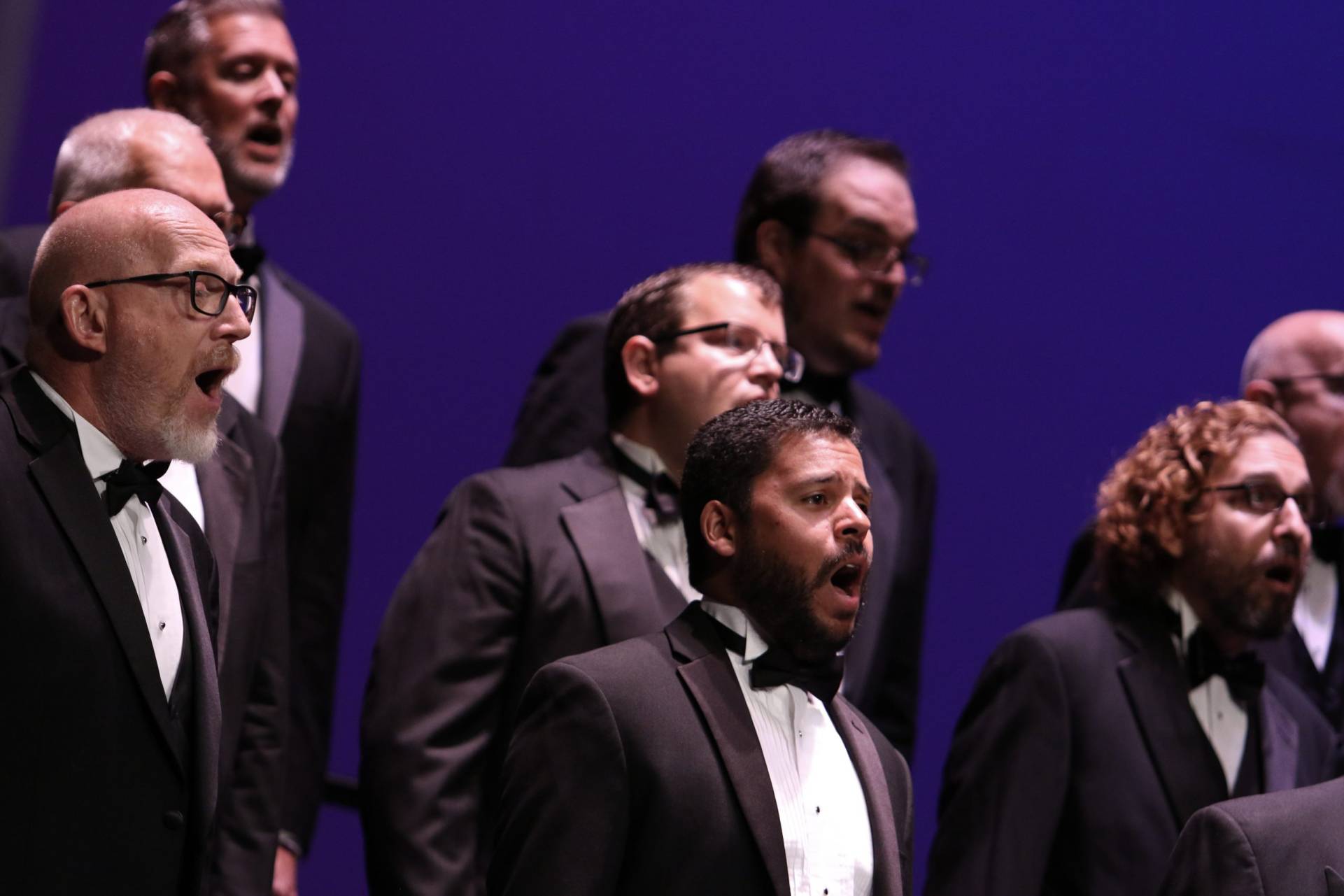 formal male presenting singers in tuxedos