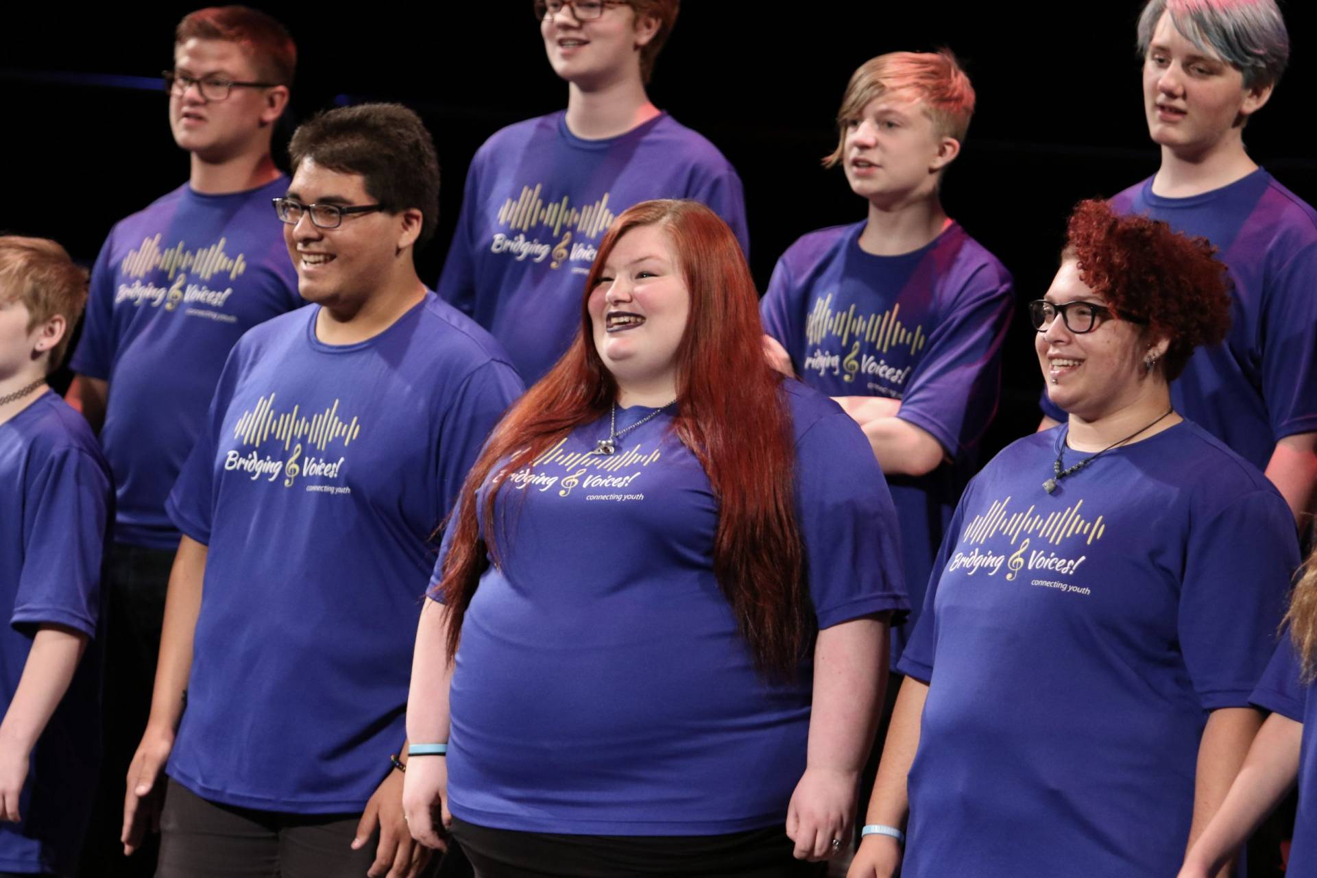 young adult singers smiling and looking toward audience