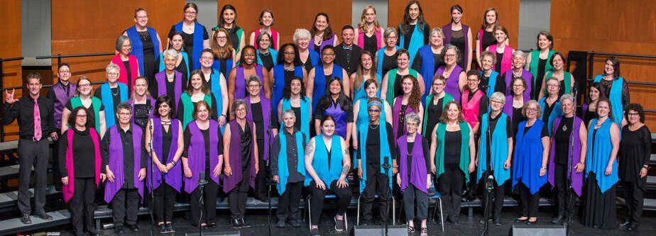 Choir photo of singers in multicolored feminine and masculine vests