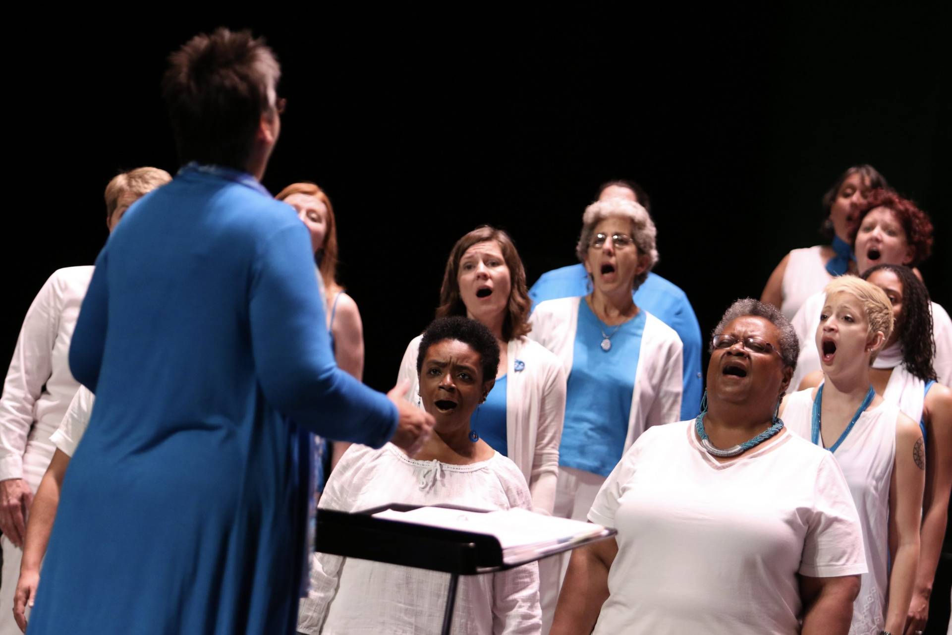 women singing with concentration and wide mouths